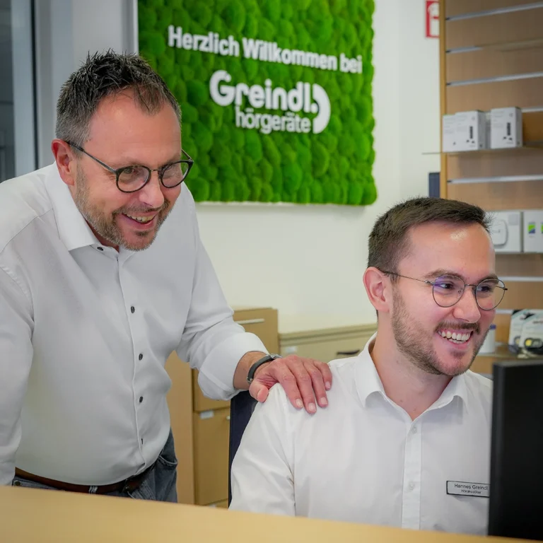 Teammitglied von Hörgeräte Greindl bei der Beratung im Empfangsbereich